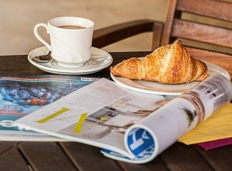 magazine, cup of coffee and croissant