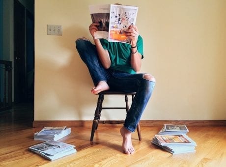 person sitting on chair reading magazine