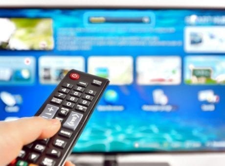 person using remote control on tv