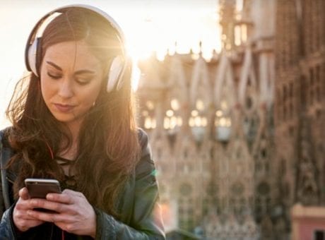 woman with headphones looking at phone